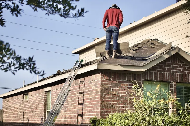 Professional roofer working on a residential roof in Zenda